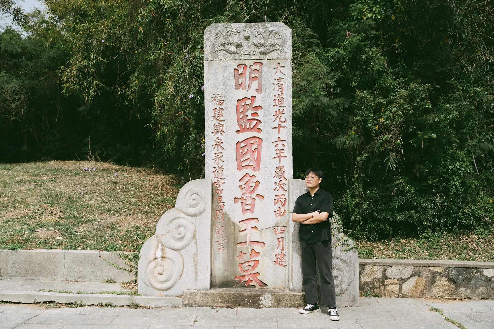man standing infront of a tombstone